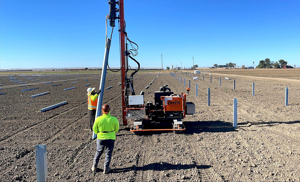Piles are driven into the ground in preparation for a solar tracker installation.
