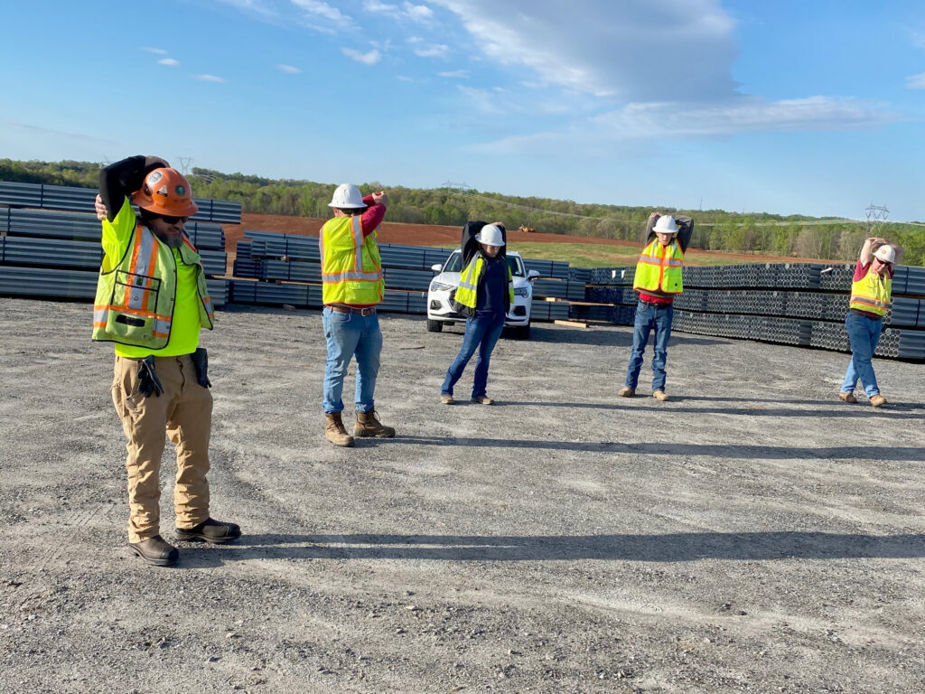 Workers stretch before a day on the solar construction job.
