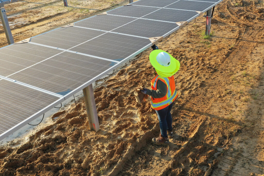 An Ampacity worker protects herself from the sun on the jobsite with a wide-brimmed hat.