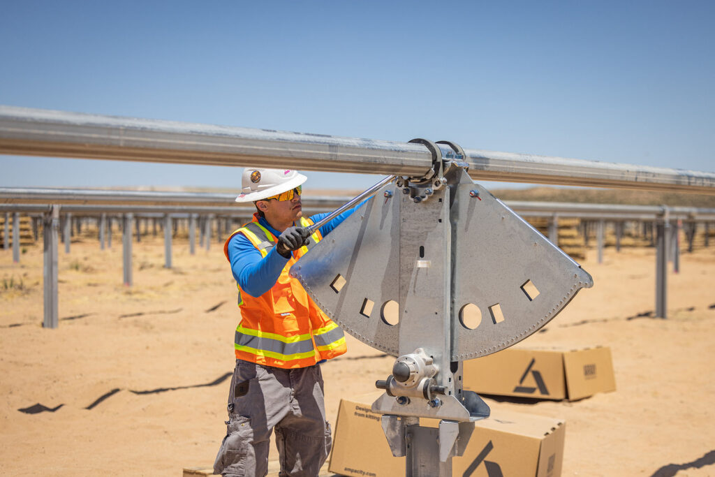 Field technician installing a solar tracker at a solar project using pre-kitted materials from Ampacity